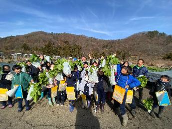 東桂小の児童が水かけ菜を掲げる様子